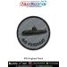 A round INS Arighaat naval patch showing a dark grey minimalist submarine silhouette above subtle waterline shading on a textured light grey fabric background with bold navy text INS ARIGHAAT curved along the lower edge and a neat black merrow border - id